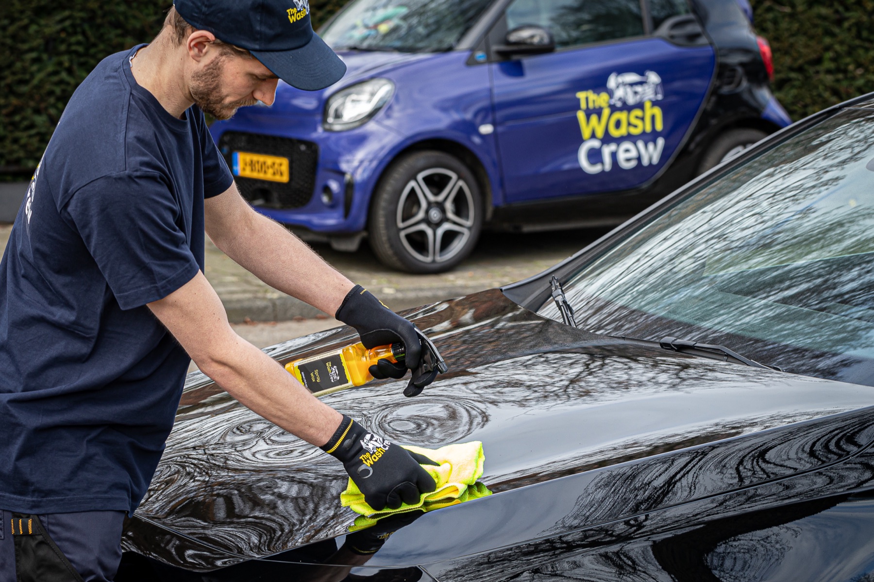 Een medewerker verzorgt de lak van een auto